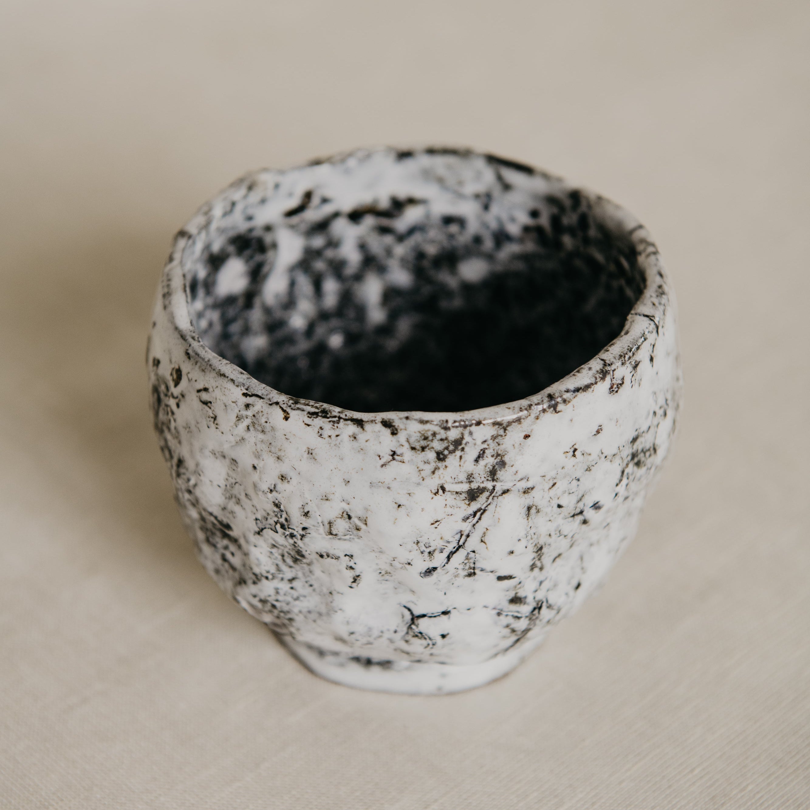 Ceramic cup with textured surface on a beige background
