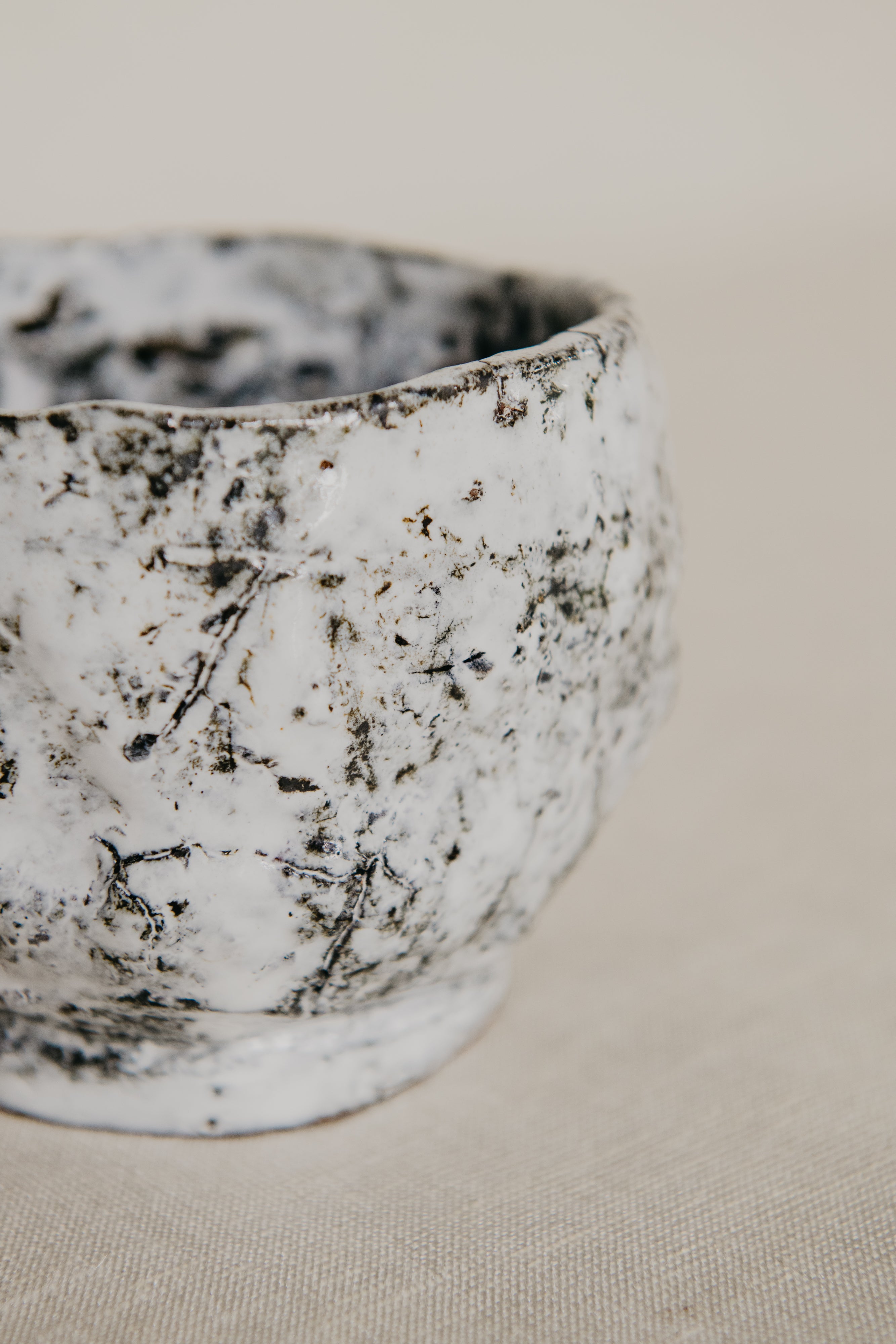 Close-up of a textured ceramic bowl on a neutral background