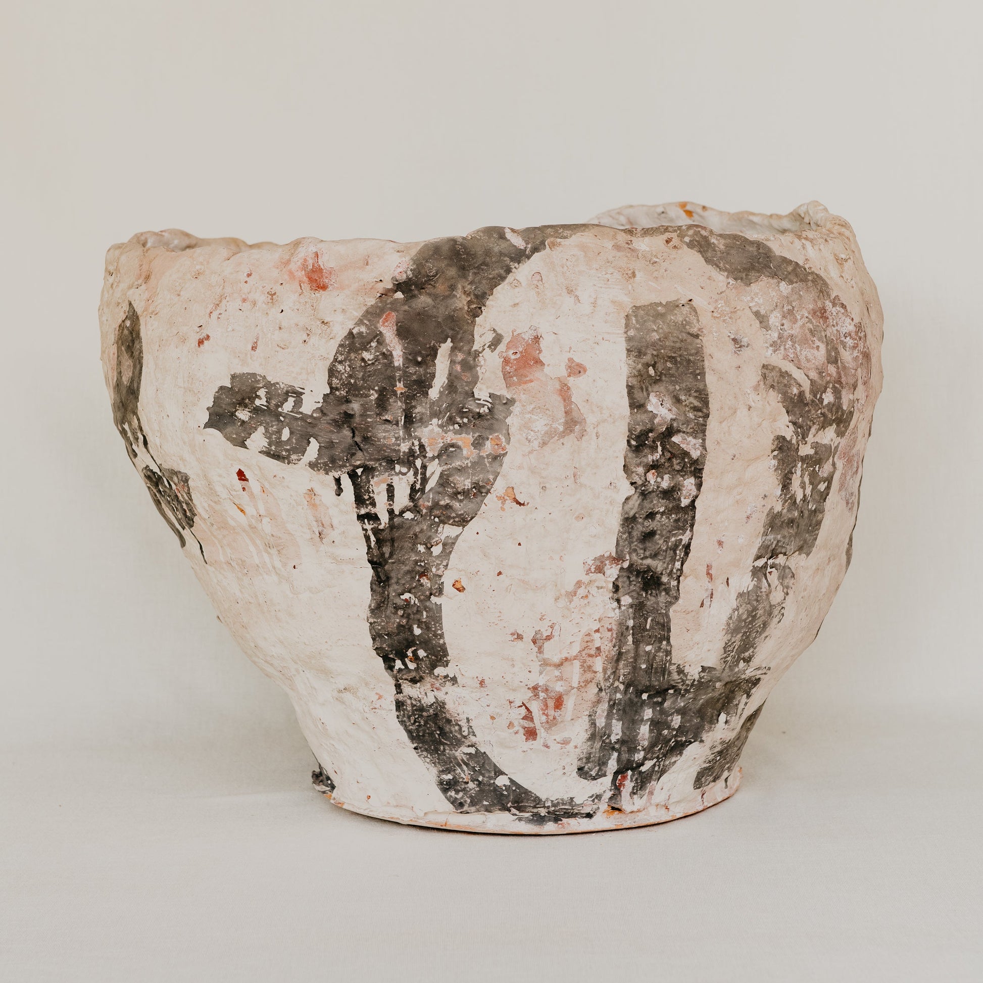 Ceramic pot with textured surface on a plain background