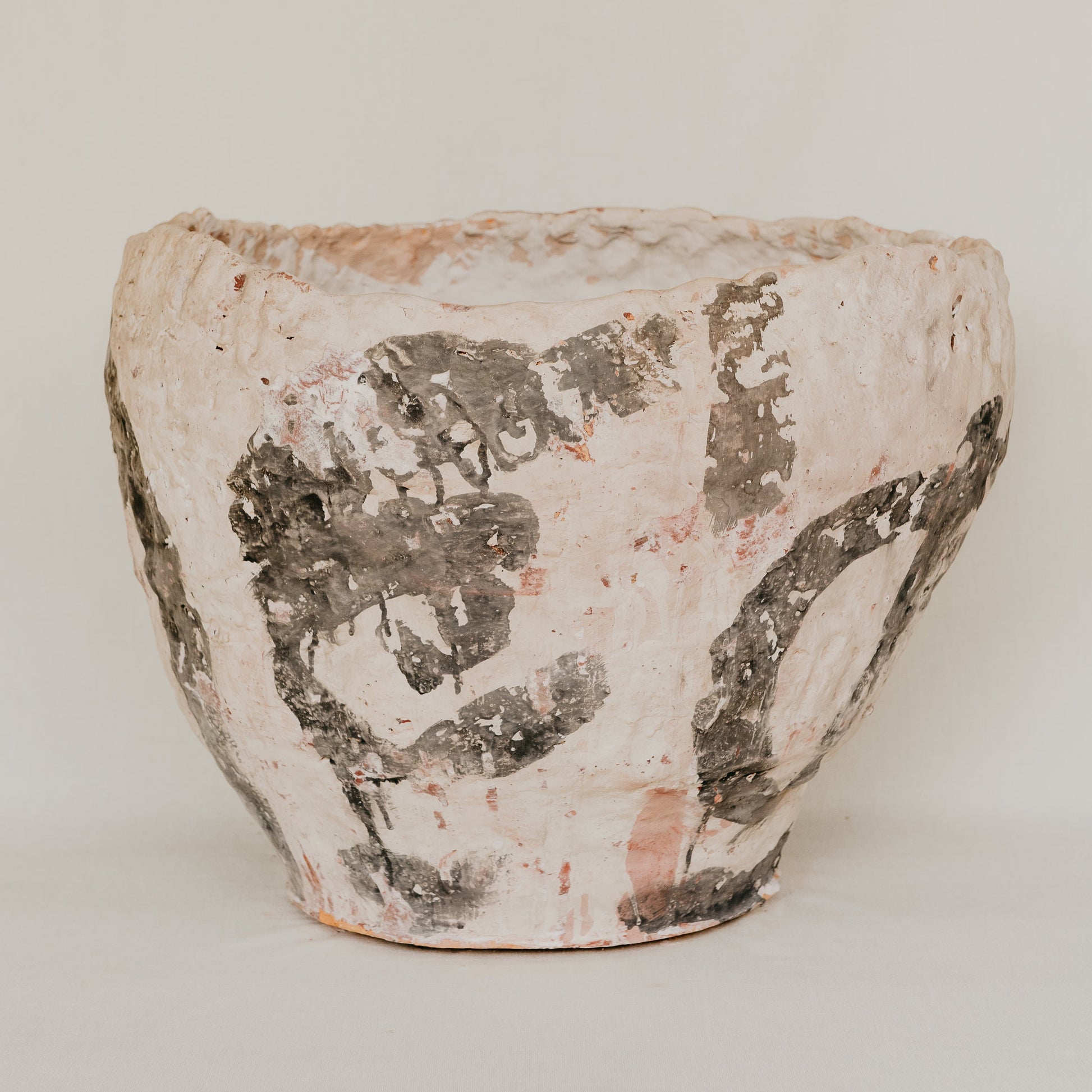 Ceramic pot with textured surface on a plain background