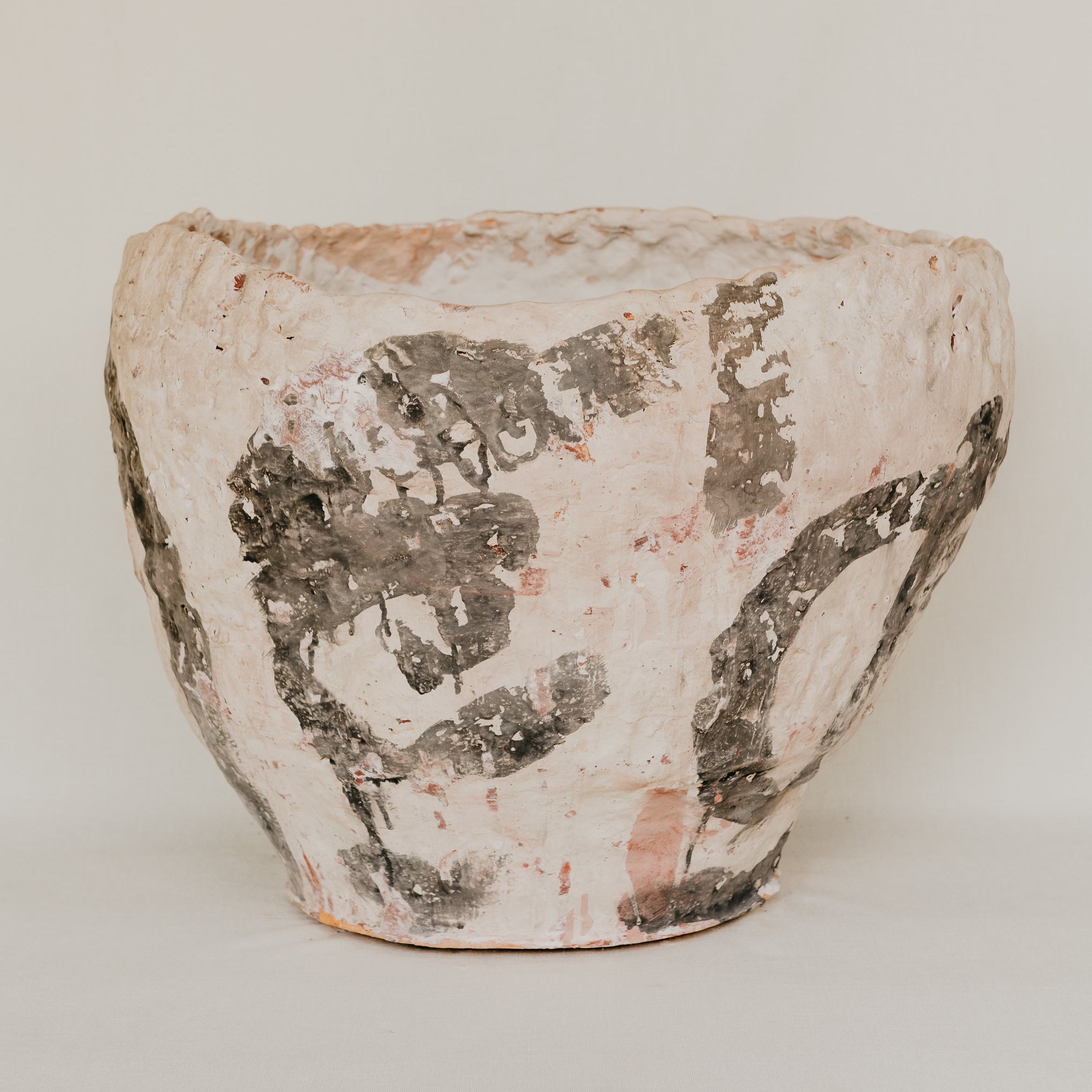 Ceramic pot with textured surface on a plain background