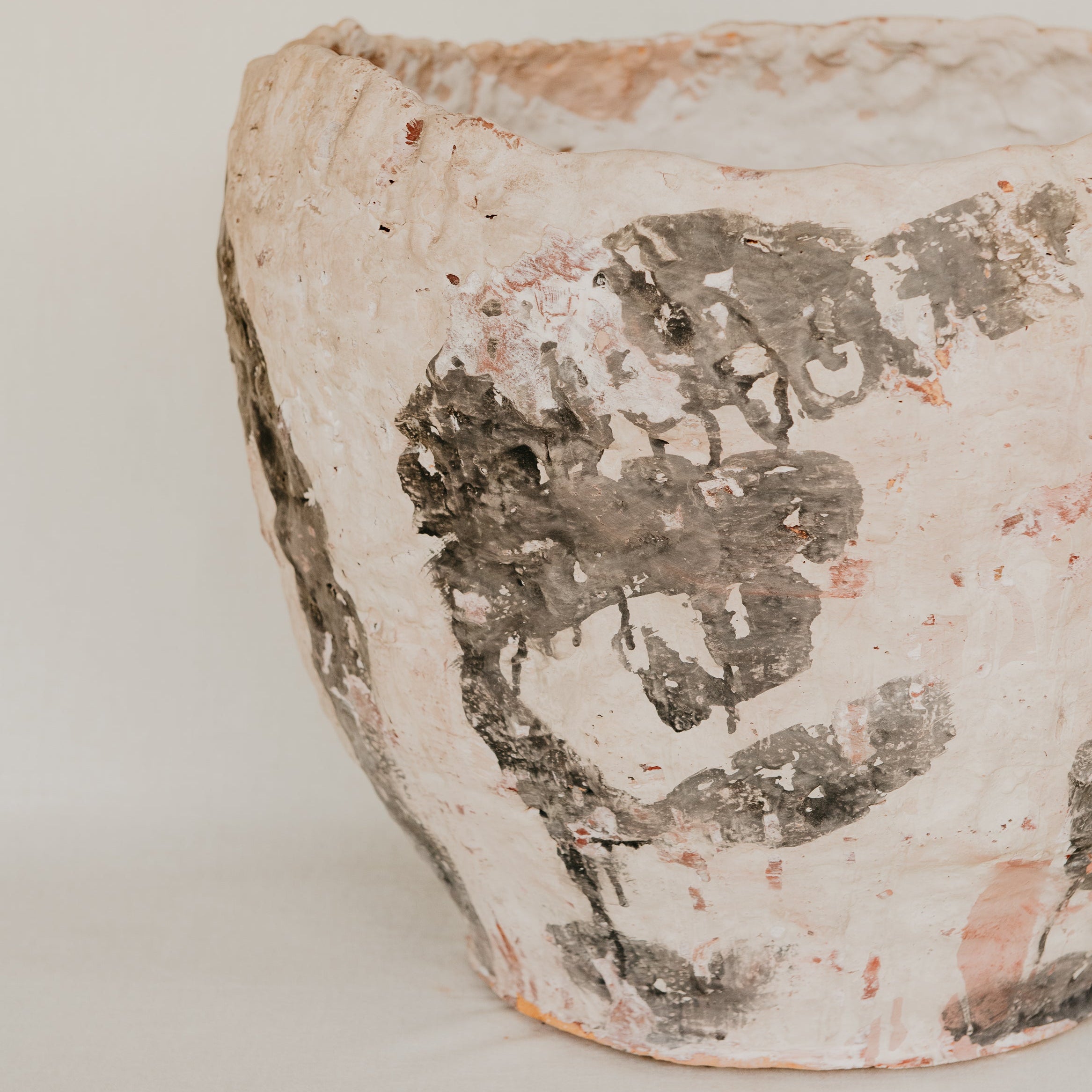 Close-up of a ceramic pot with decorative patterns on a light background