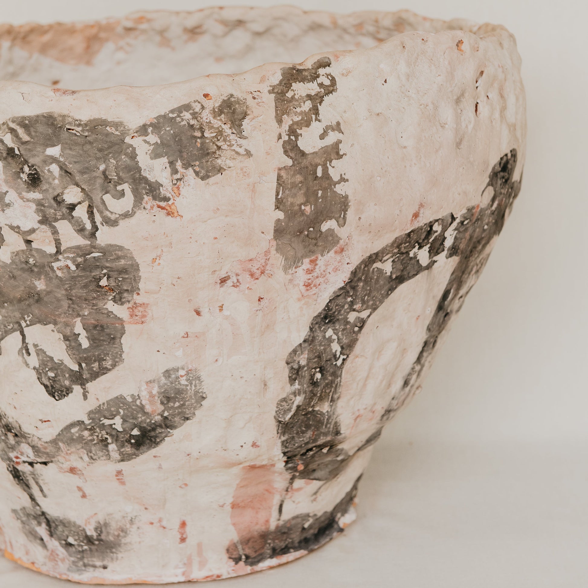 Vintage ceramic pot with chipped glaze on a white background