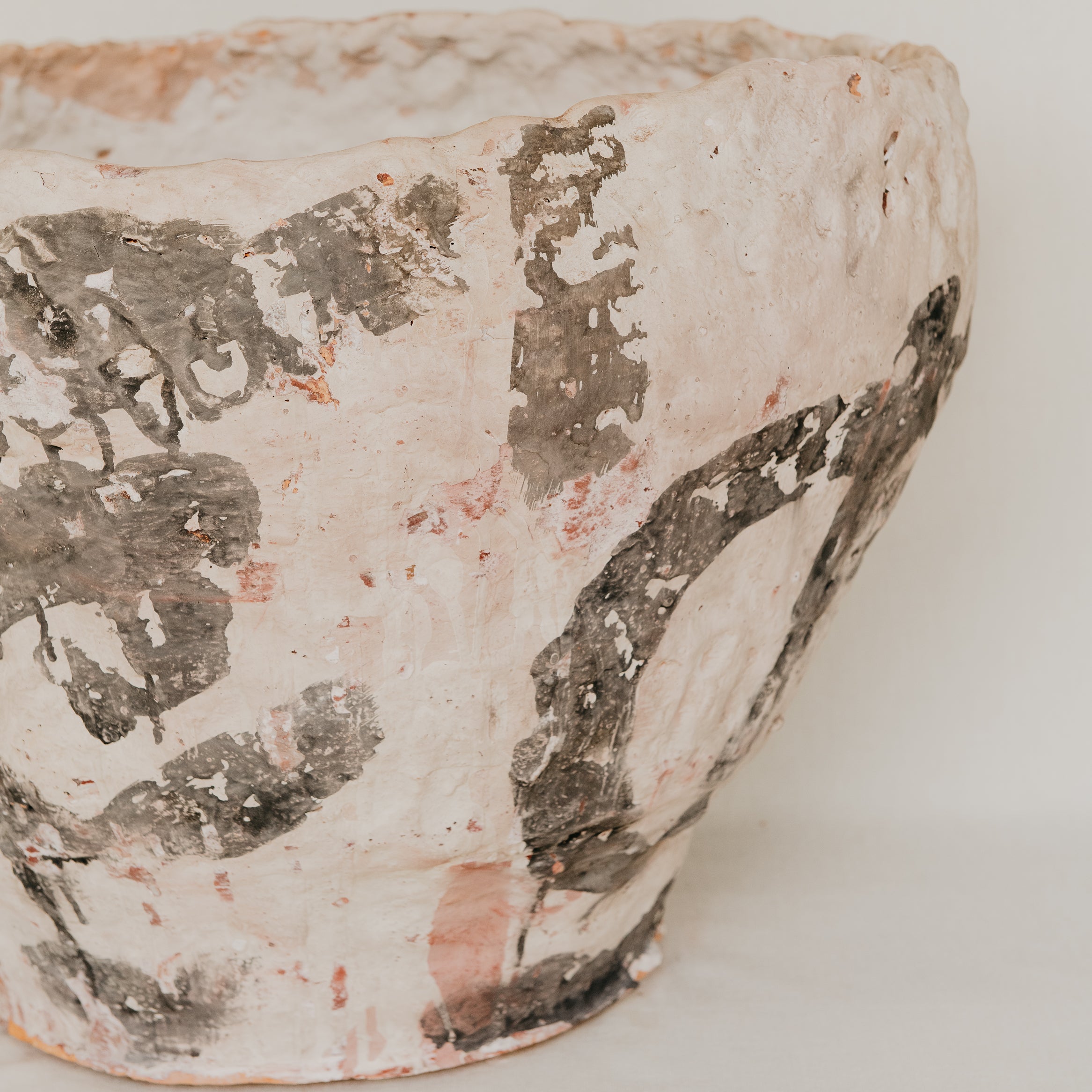 Vintage ceramic pot with chipped glaze on a white background