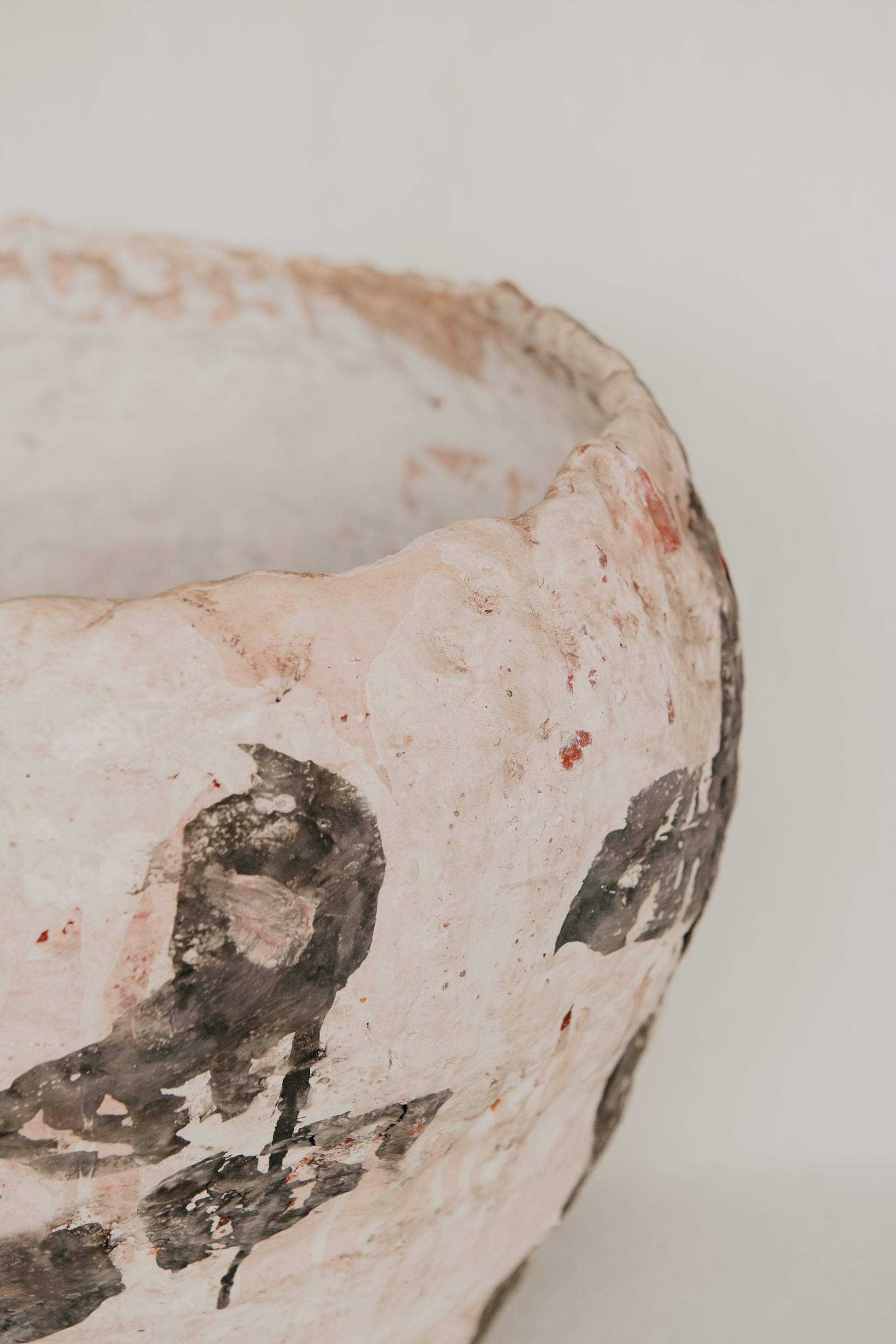 Close-up of a ceramic bowl with black floral patterns on a light background