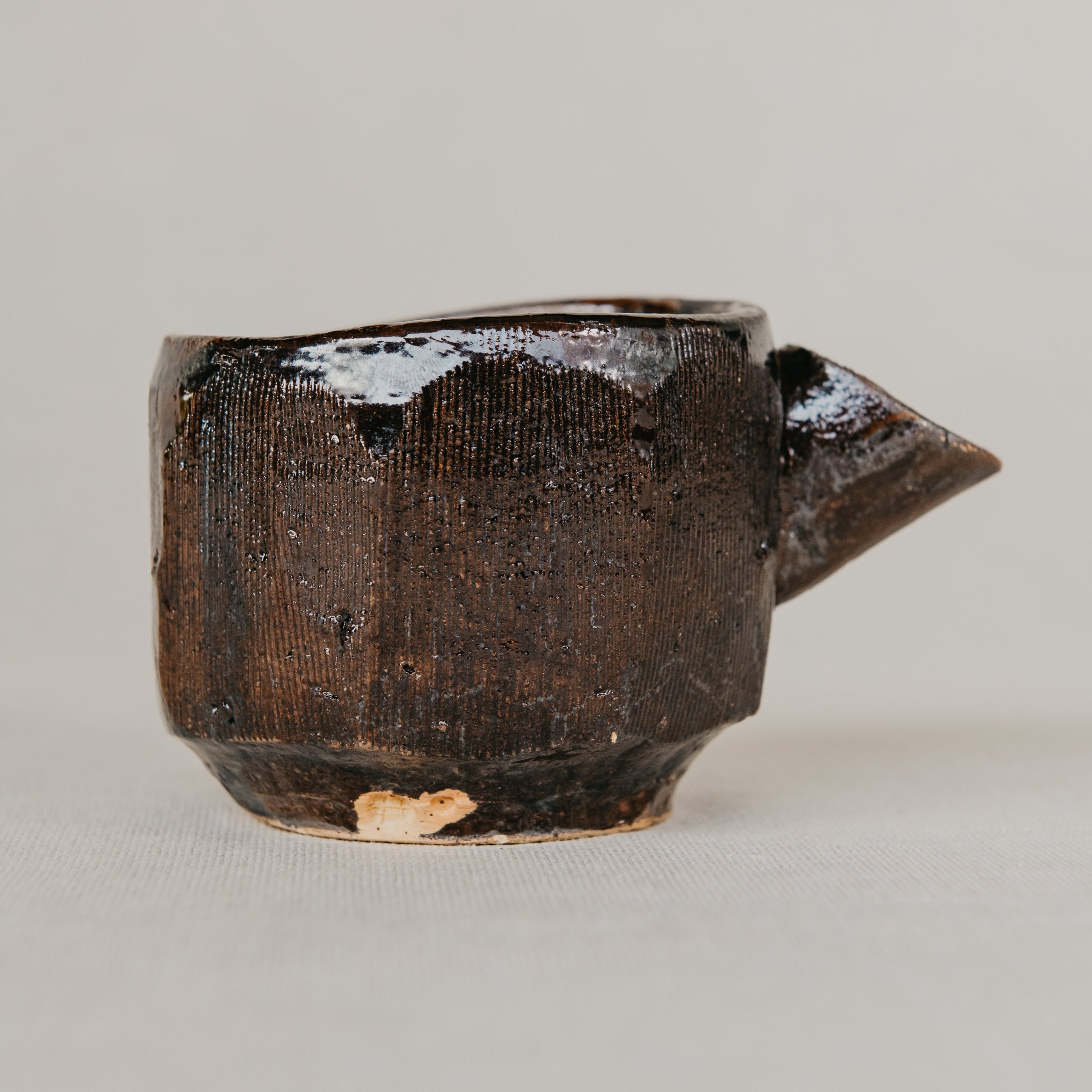 Brown ceramic teapot on a light gray background