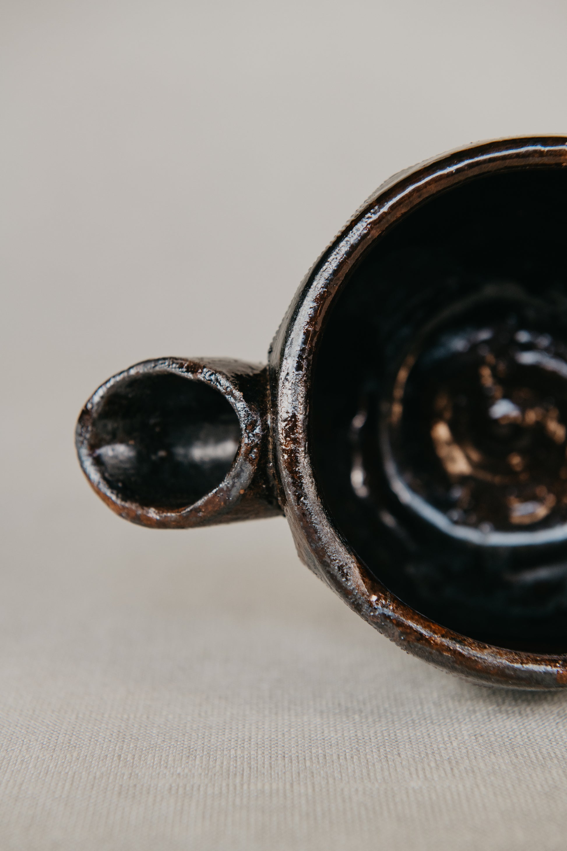 Close-up of a dark ceramic mug on a light fabric background