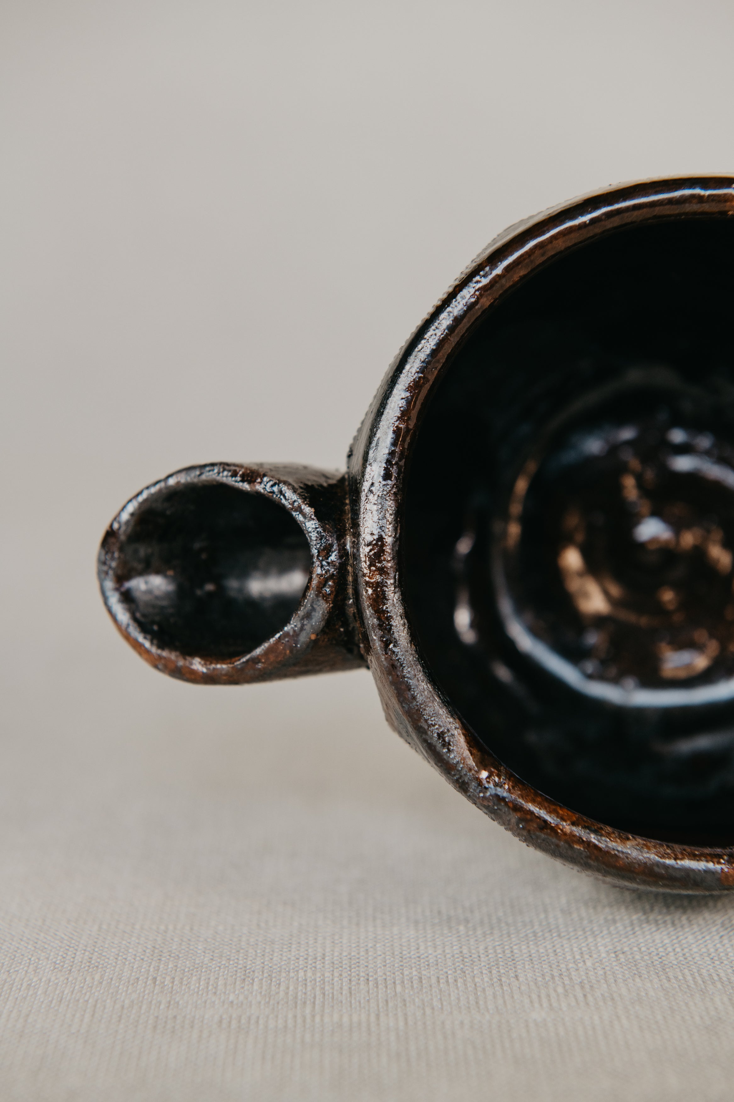 Close-up of a dark ceramic mug on a light fabric background