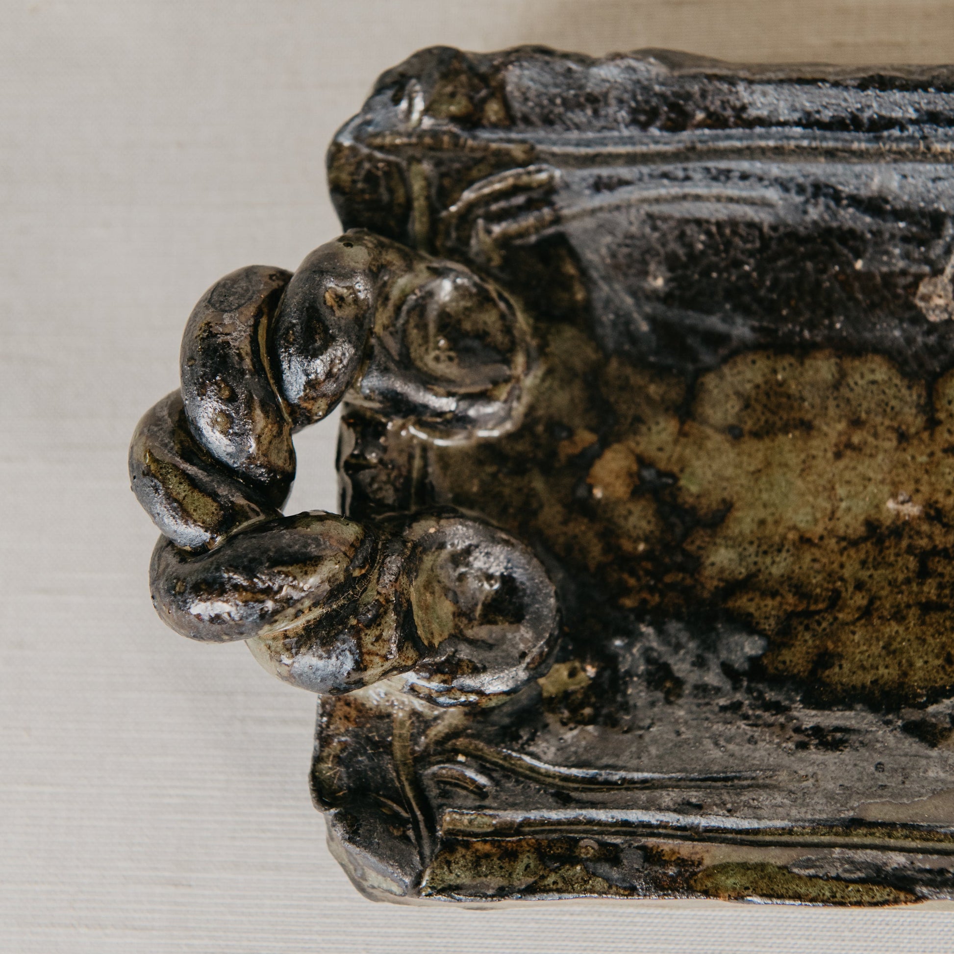 Decorative metal object with intricate design on a white background