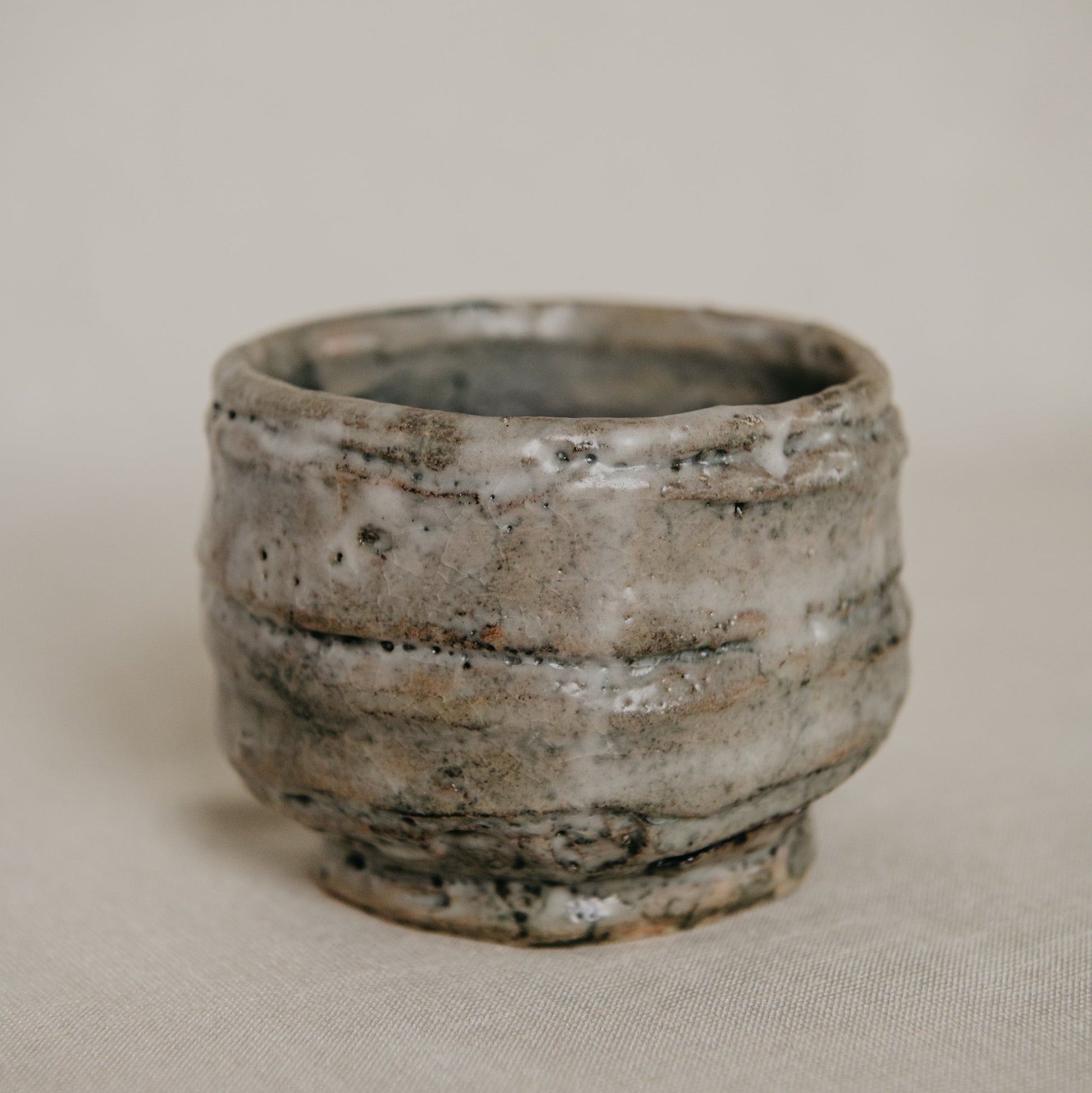 Ceramic cup with textured surface on a beige background