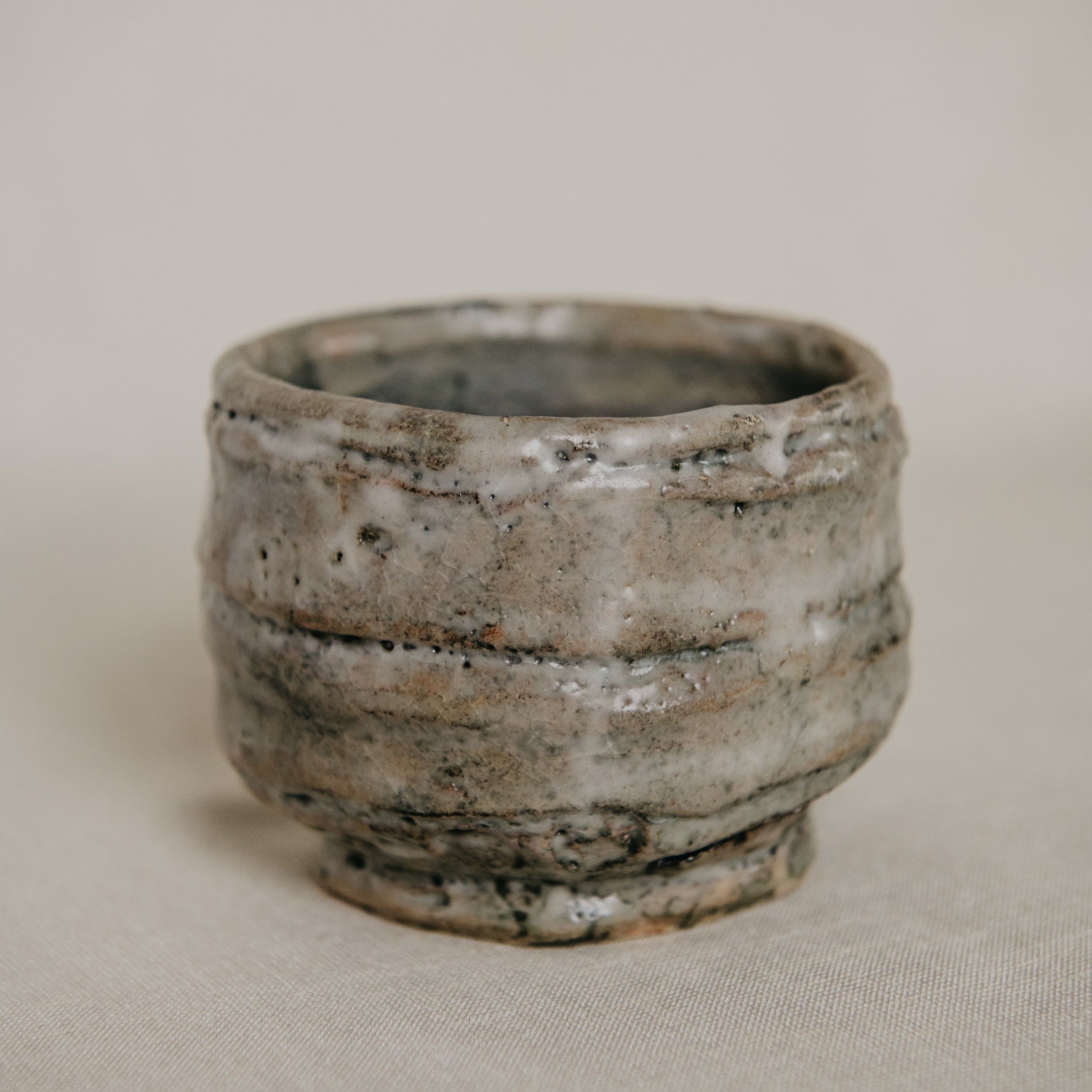 Ceramic cup with textured surface on a beige background