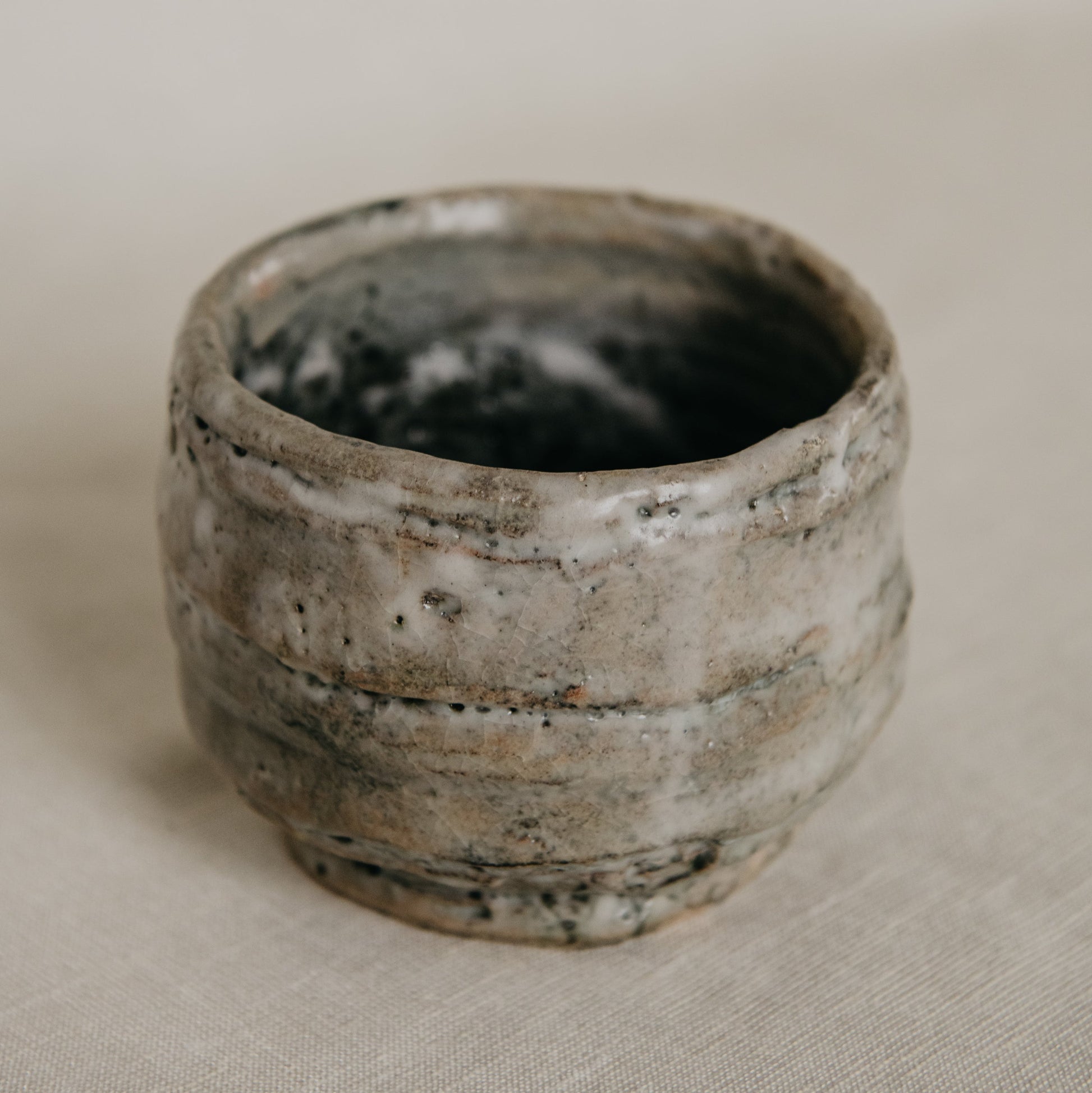 Ceramic cup with textured surface on a neutral background