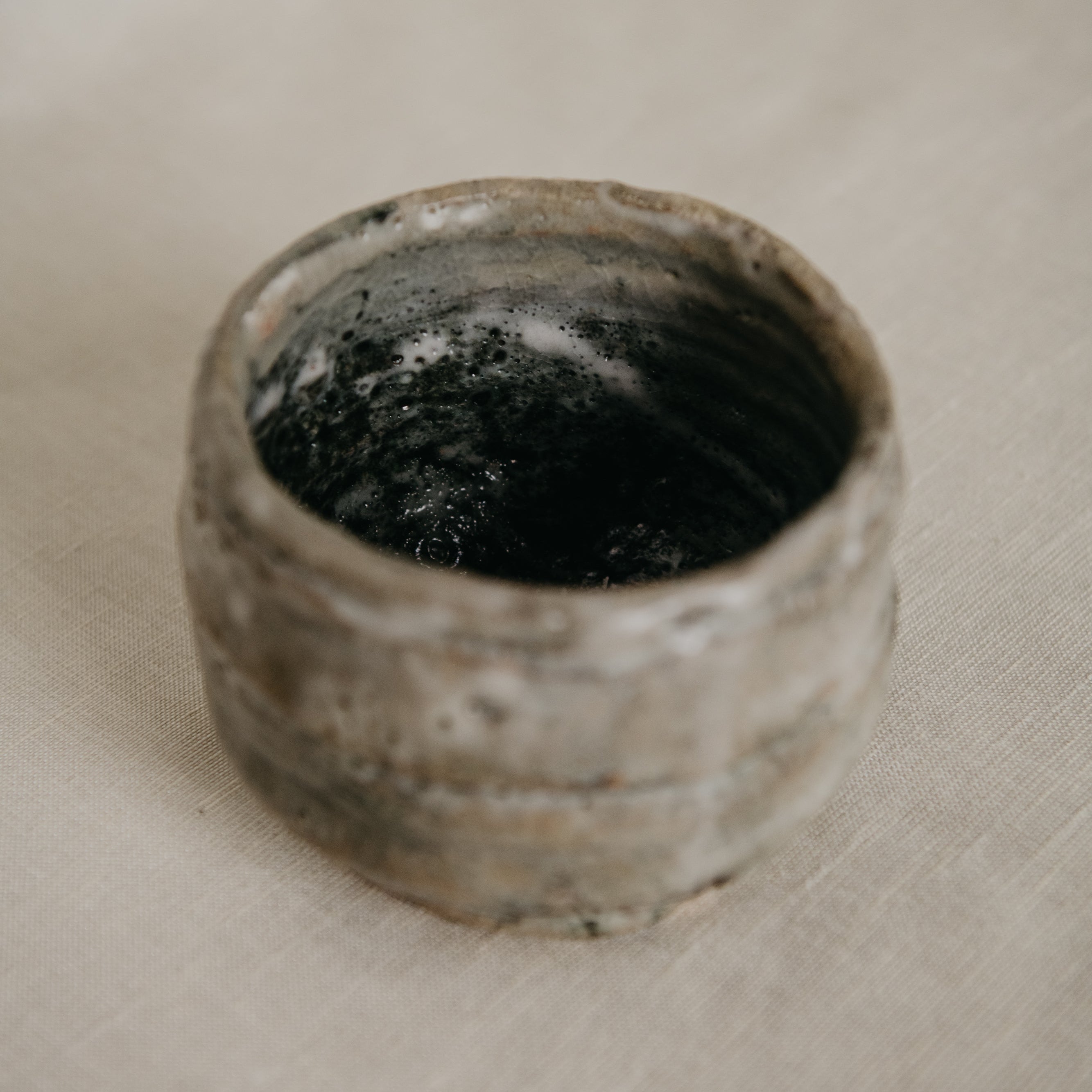 Small rustic ceramic bowl on a textured surface
