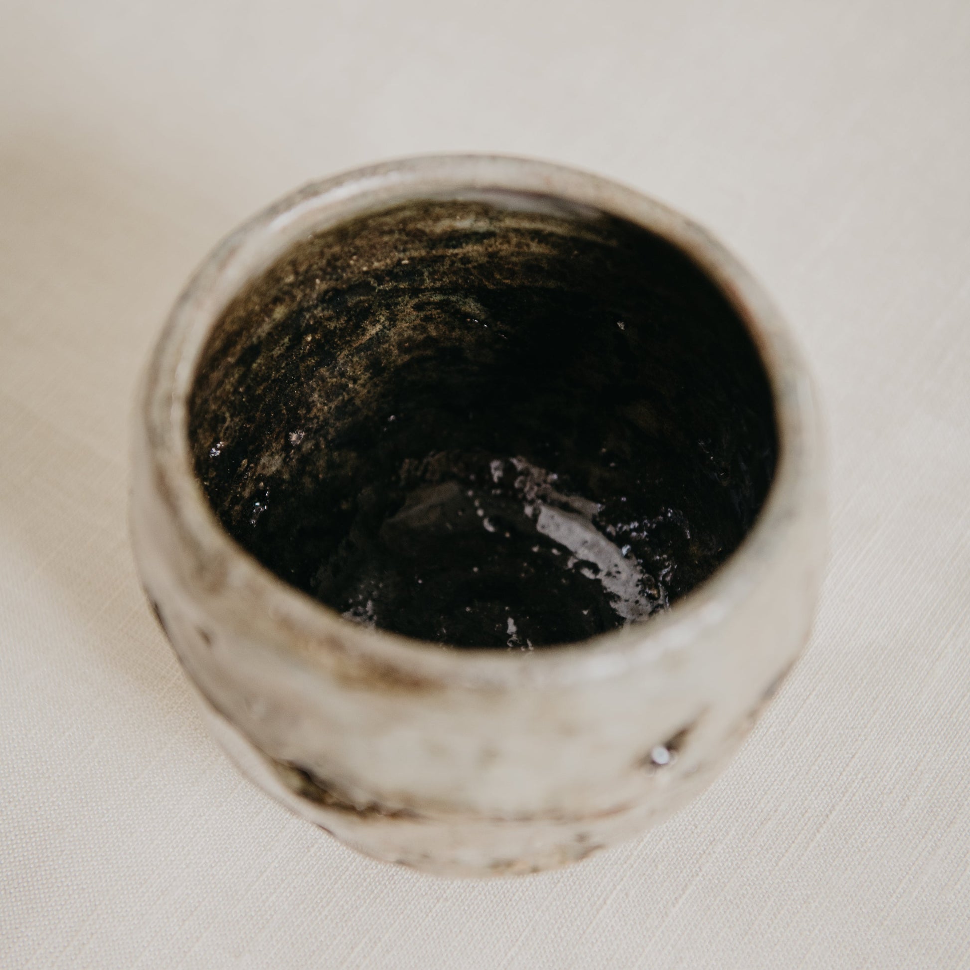 Ceramic container with dark interior on a white background