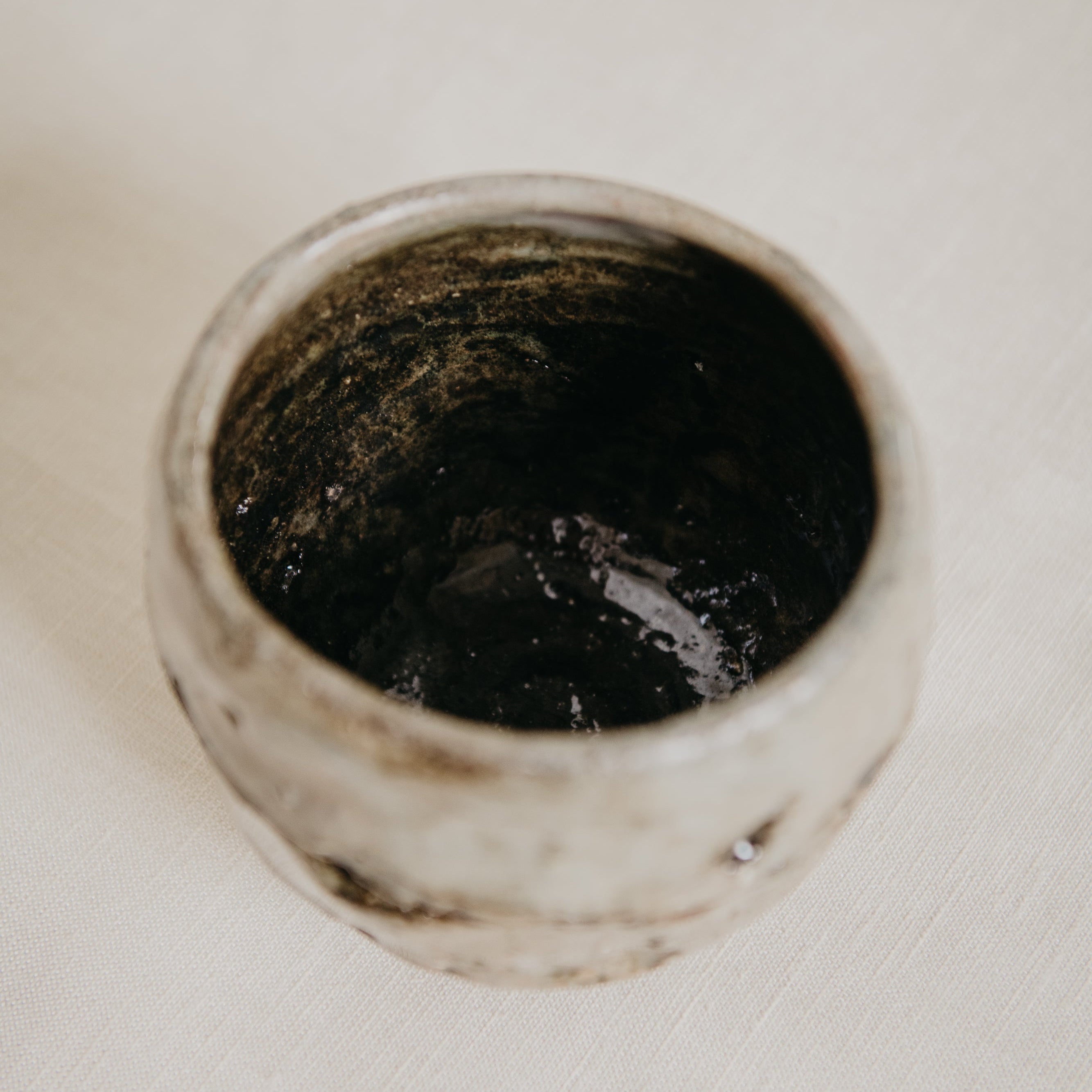 Ceramic container with dark interior on a white background