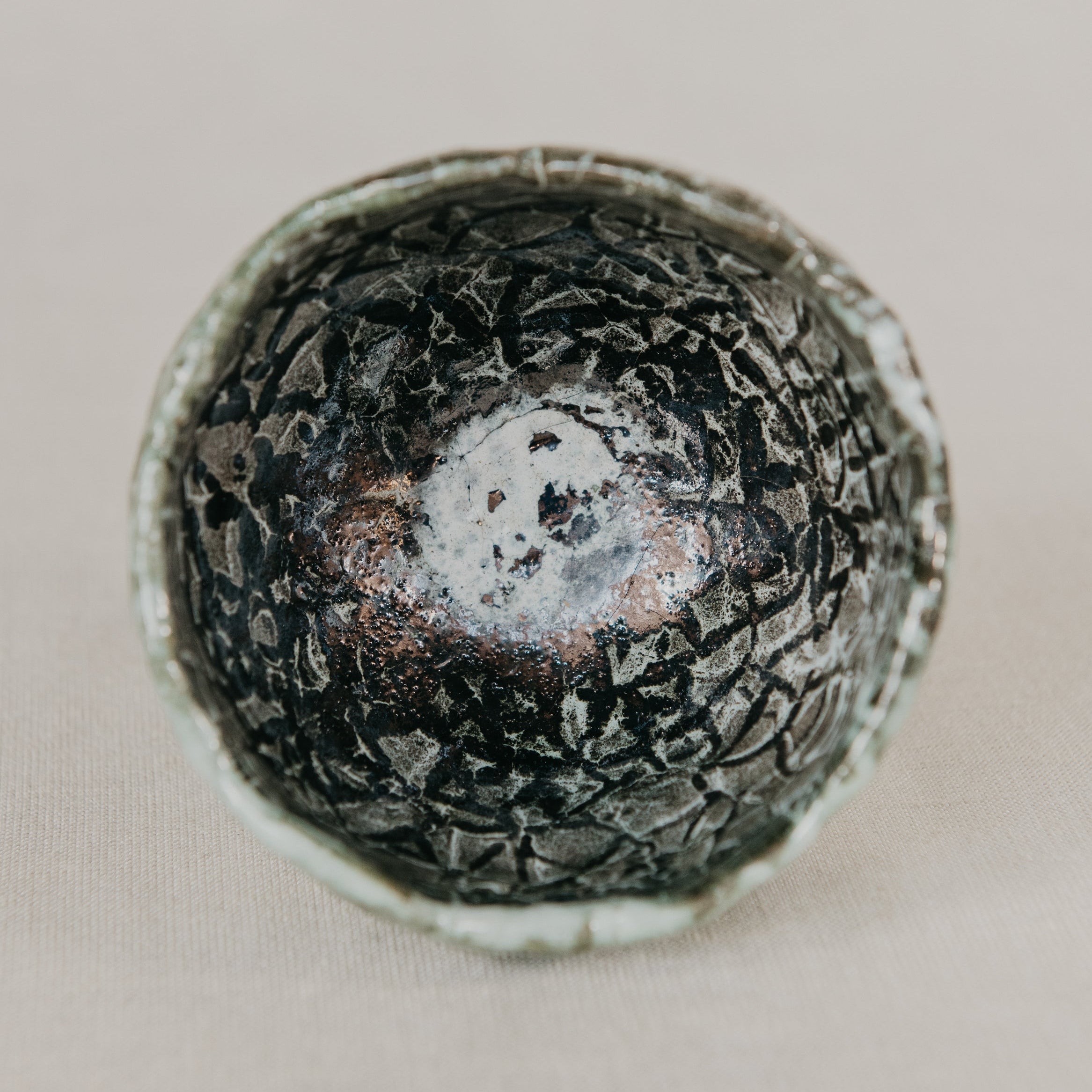 Decorative ceramic bowl with textured surface on a beige background