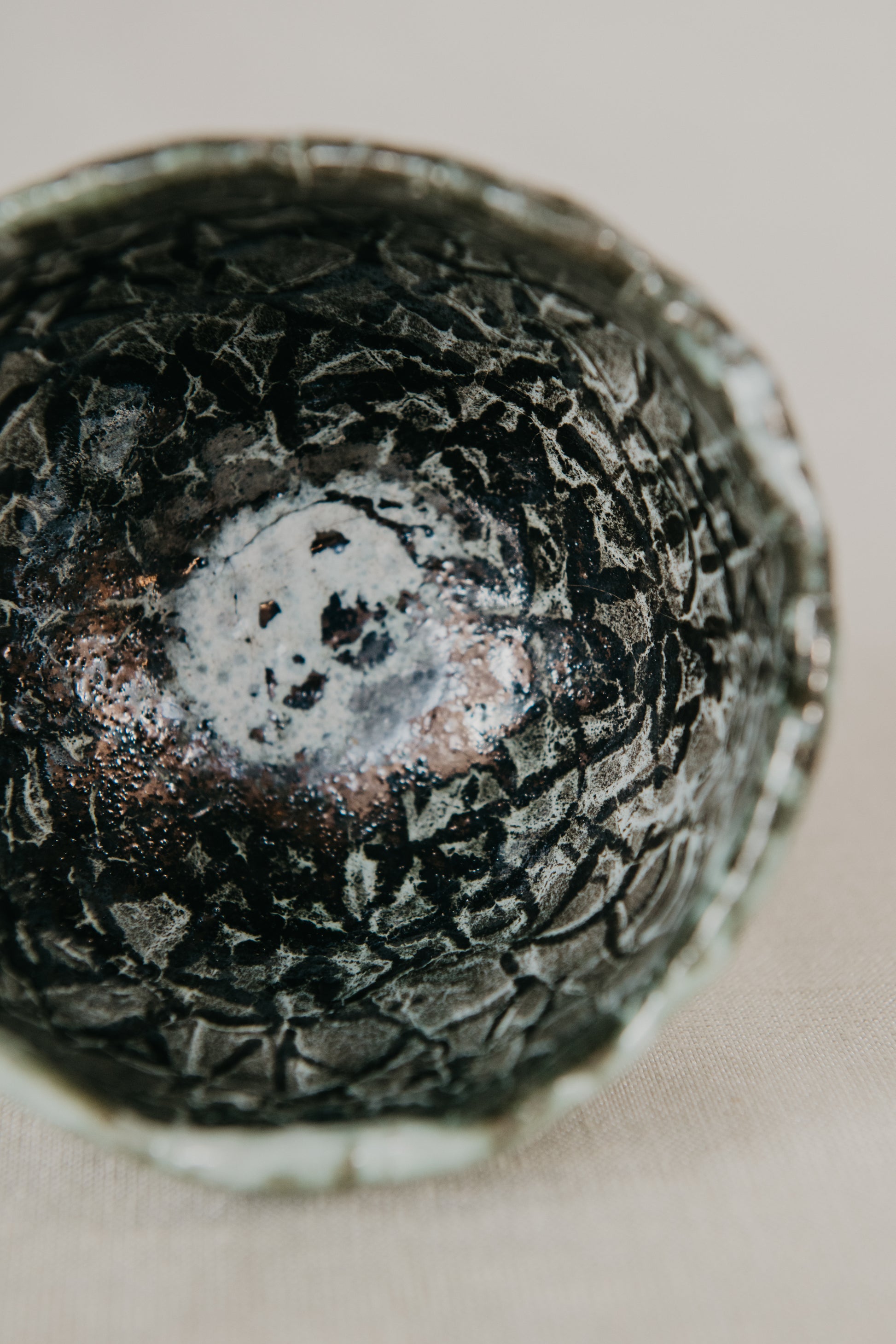 Close-up of a textured ceramic bowl with a neutral background