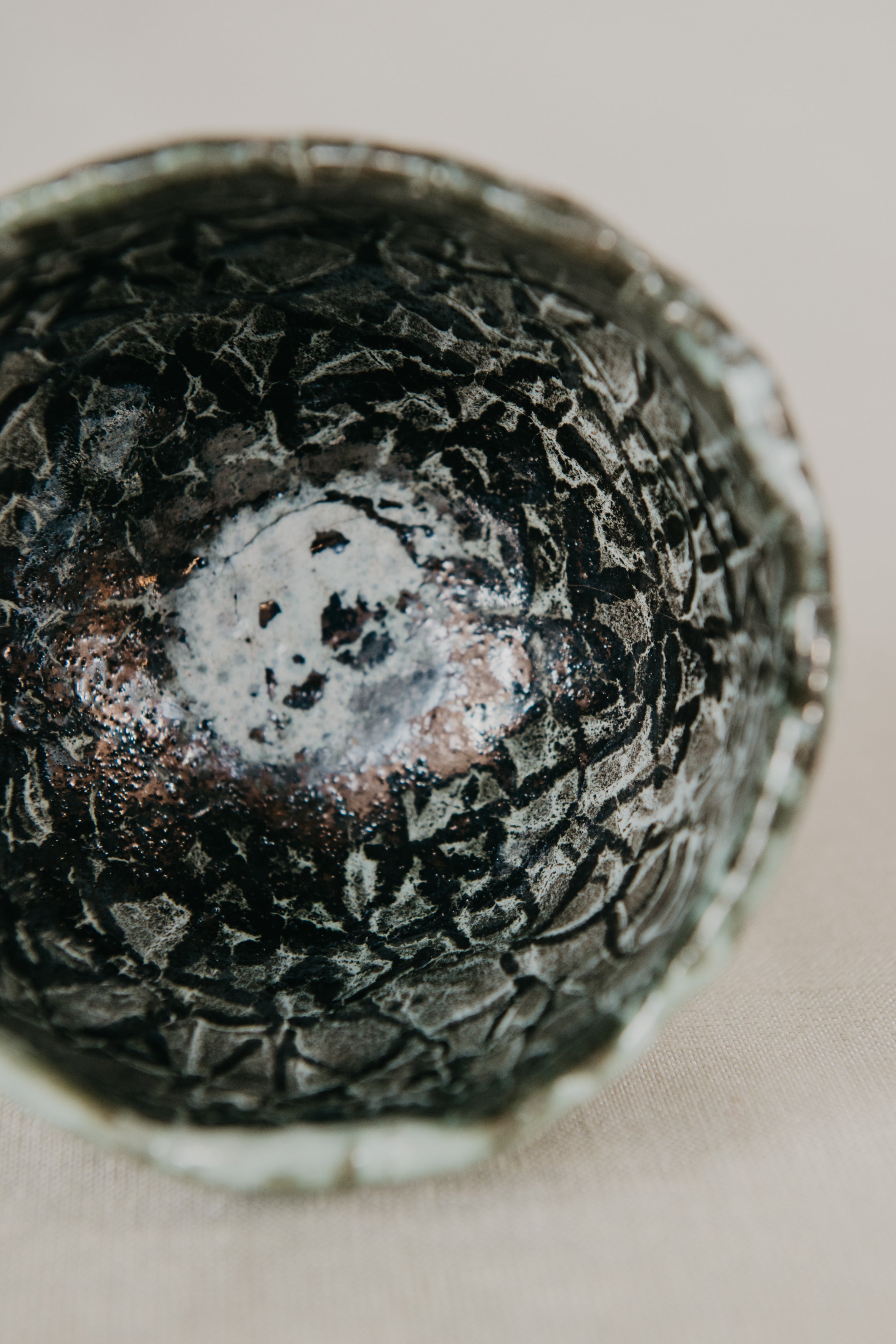 Close-up of a textured ceramic bowl with a neutral background