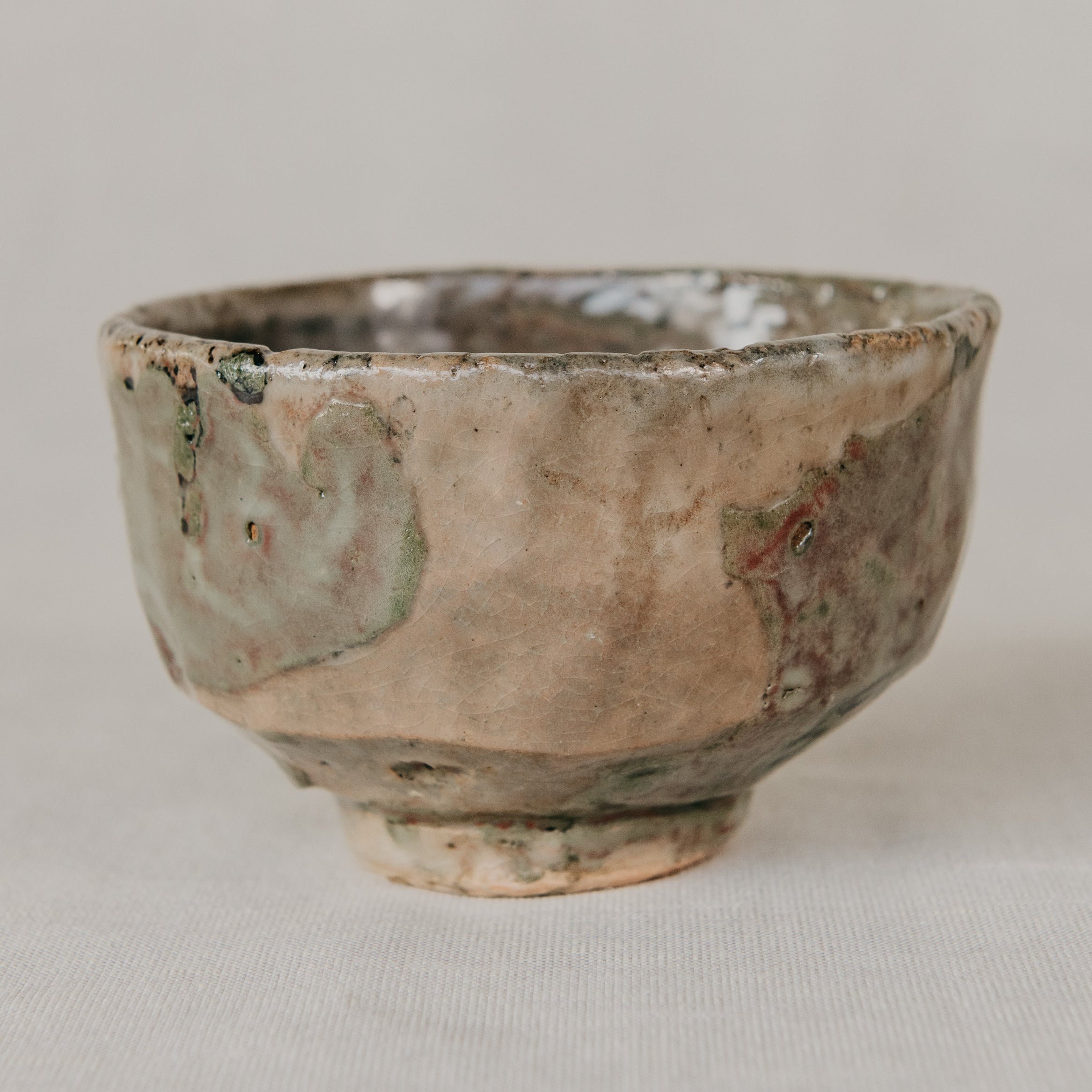 Small ceramic cup with a textured surface on a neutral background