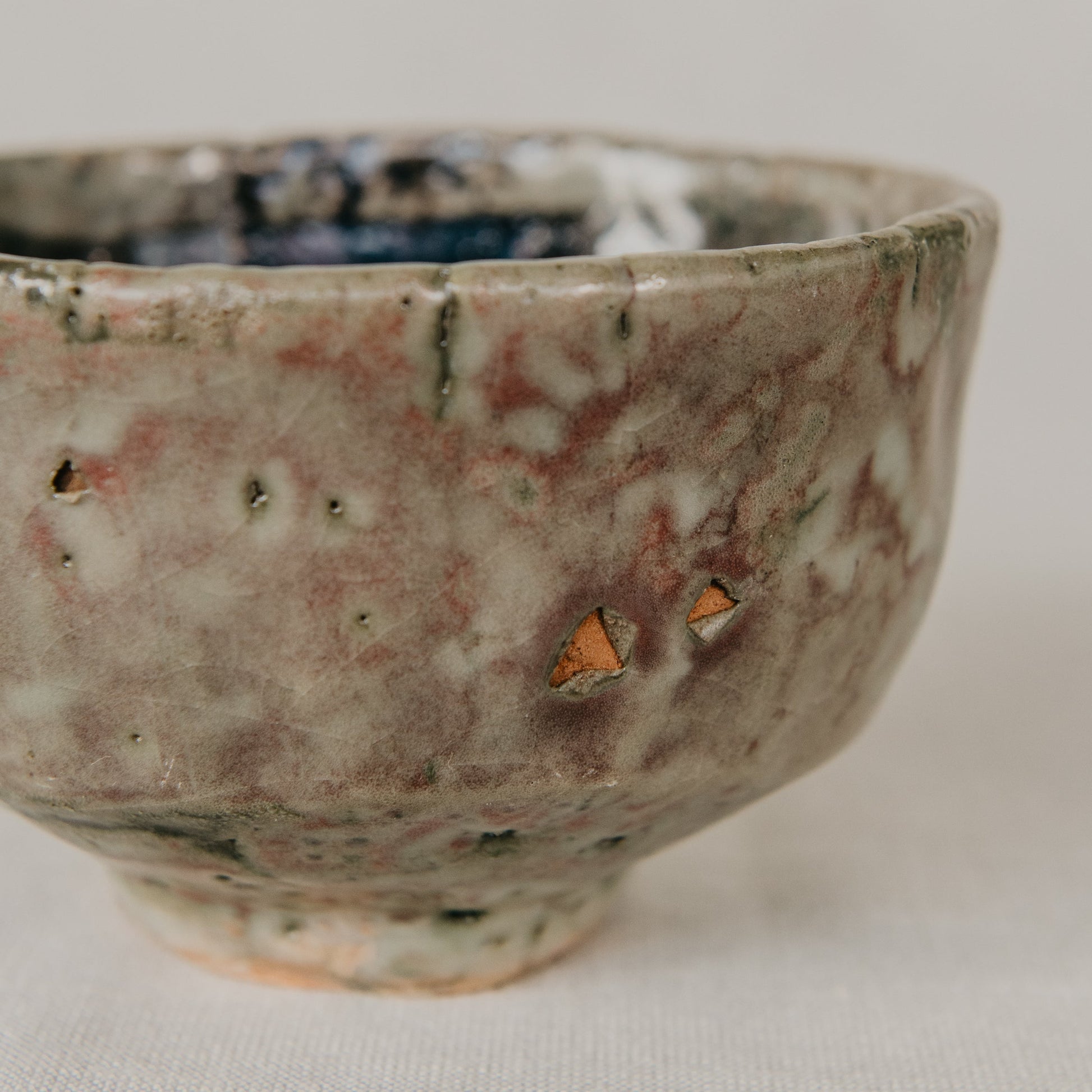 Handmade ceramic bowl with a textured surface on a neutral background