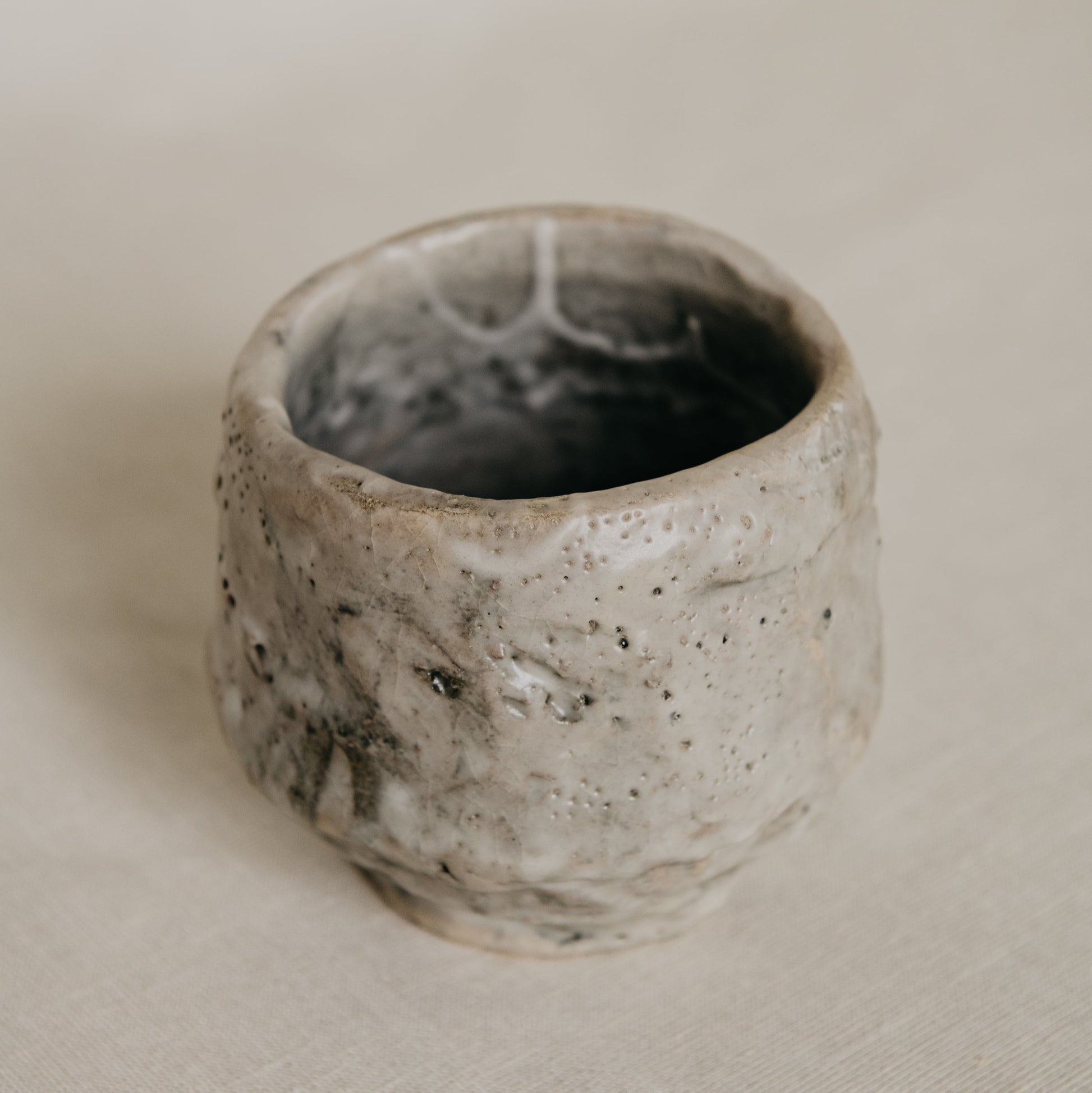 Ceramic cup with textured surface on a neutral background