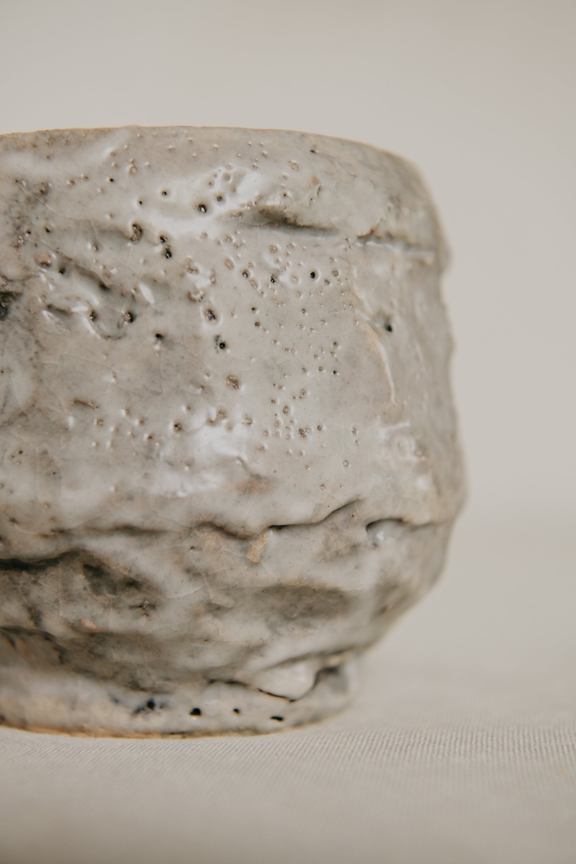 Close-up of a textured ceramic pot on a neutral background