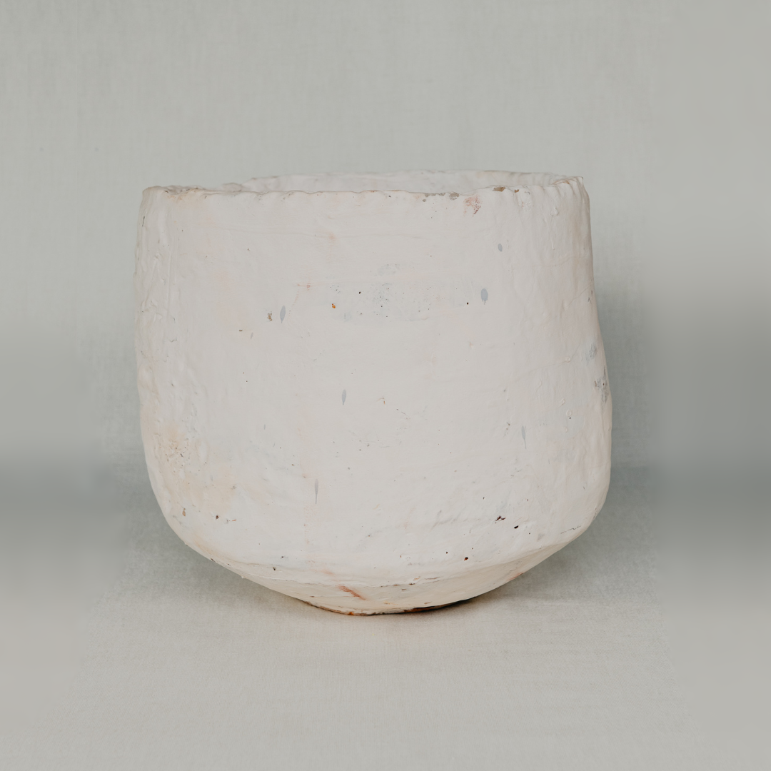 White ceramic pot with speckled texture on a light gray background