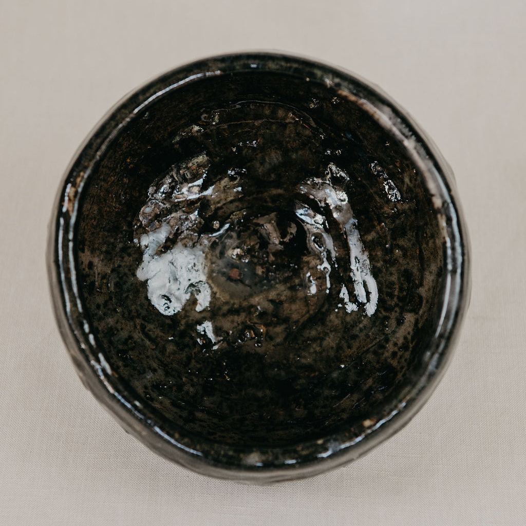 Black ceramic bowl on a beige background