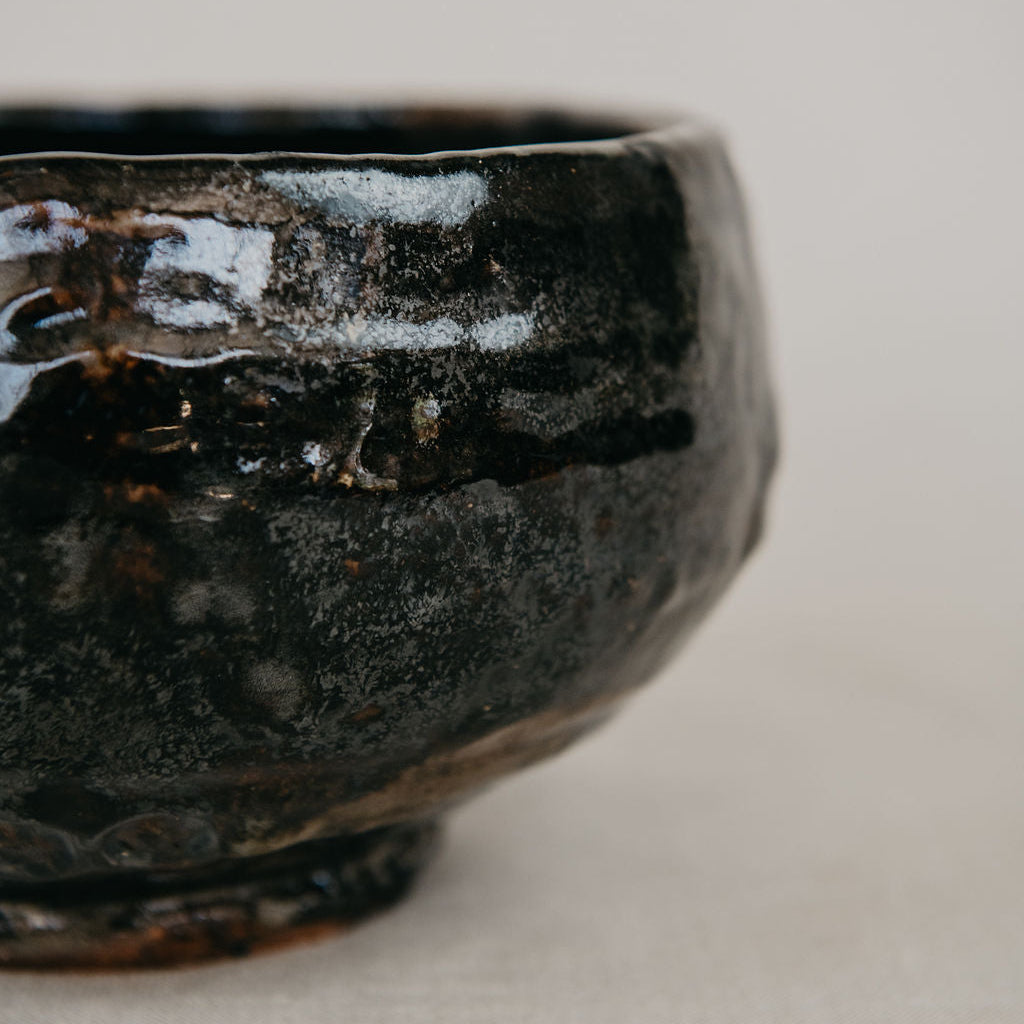 Close-up of a dark ceramic bowl on a light background