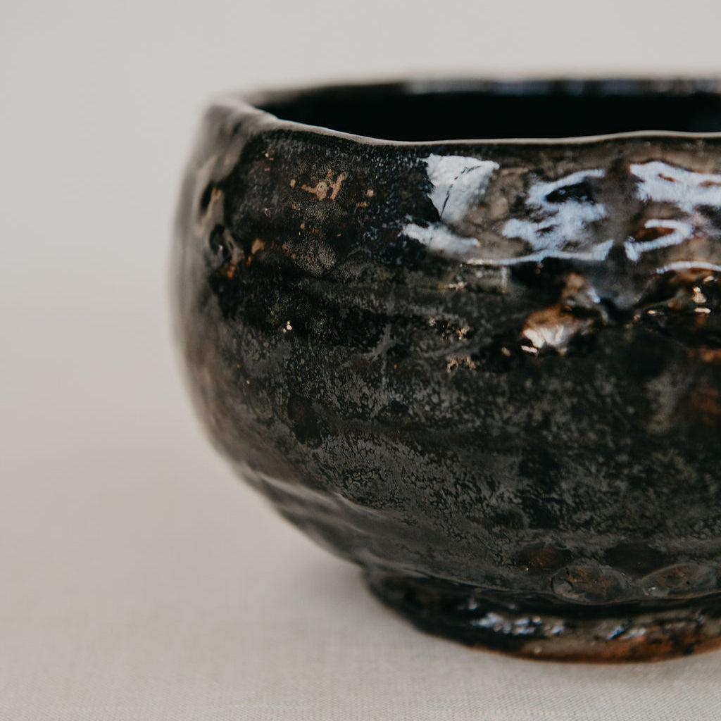 Black ceramic bowl on a light gray background