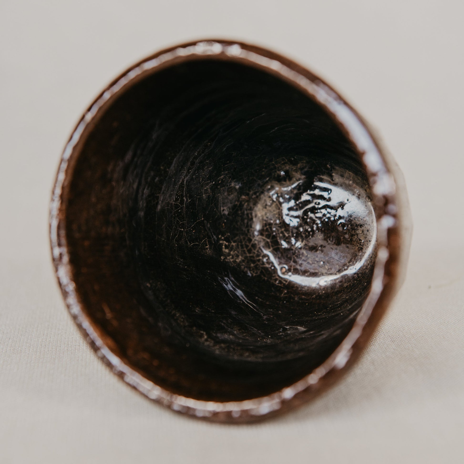 Ceramic cup with a textured interior on a neutral background