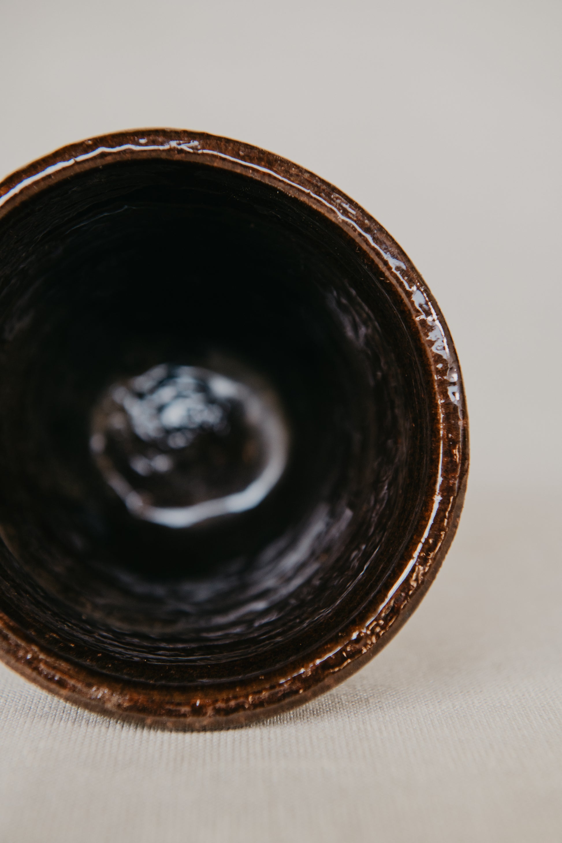 Close-up of a dark brown ceramic bowl on a light background