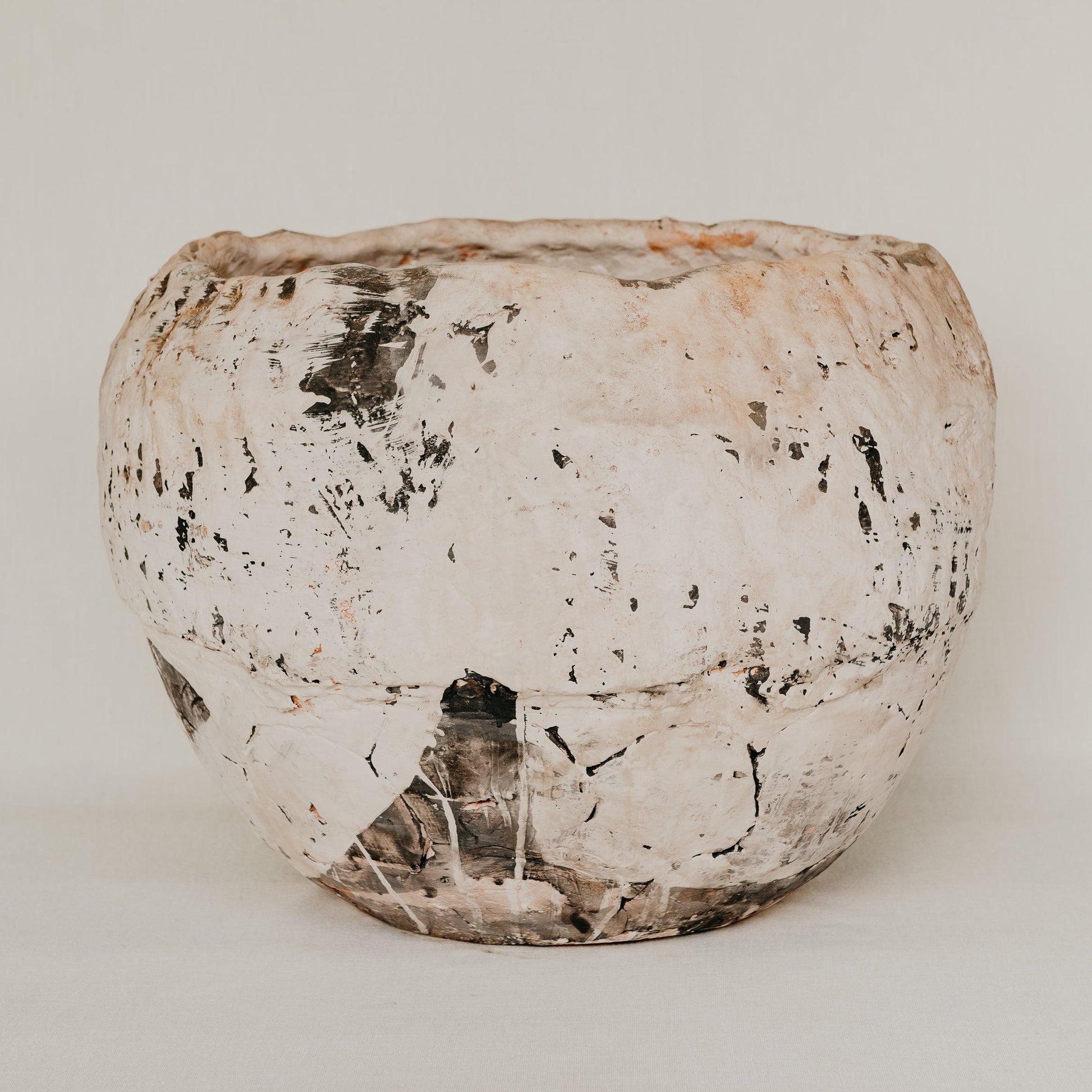 Vintage ceramic pot with a textured surface on a white background
