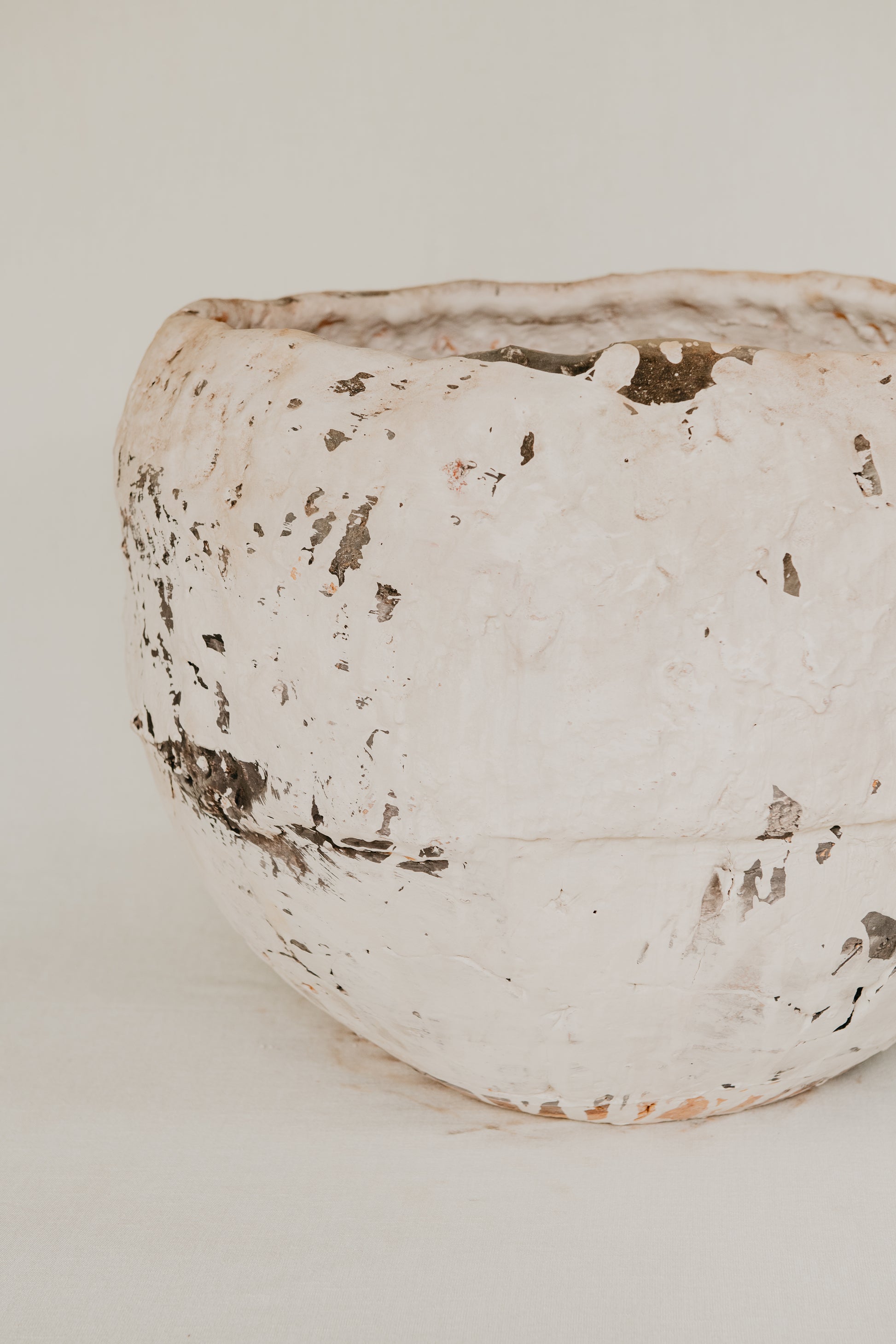 White ceramic pot with rustic texture on a light background